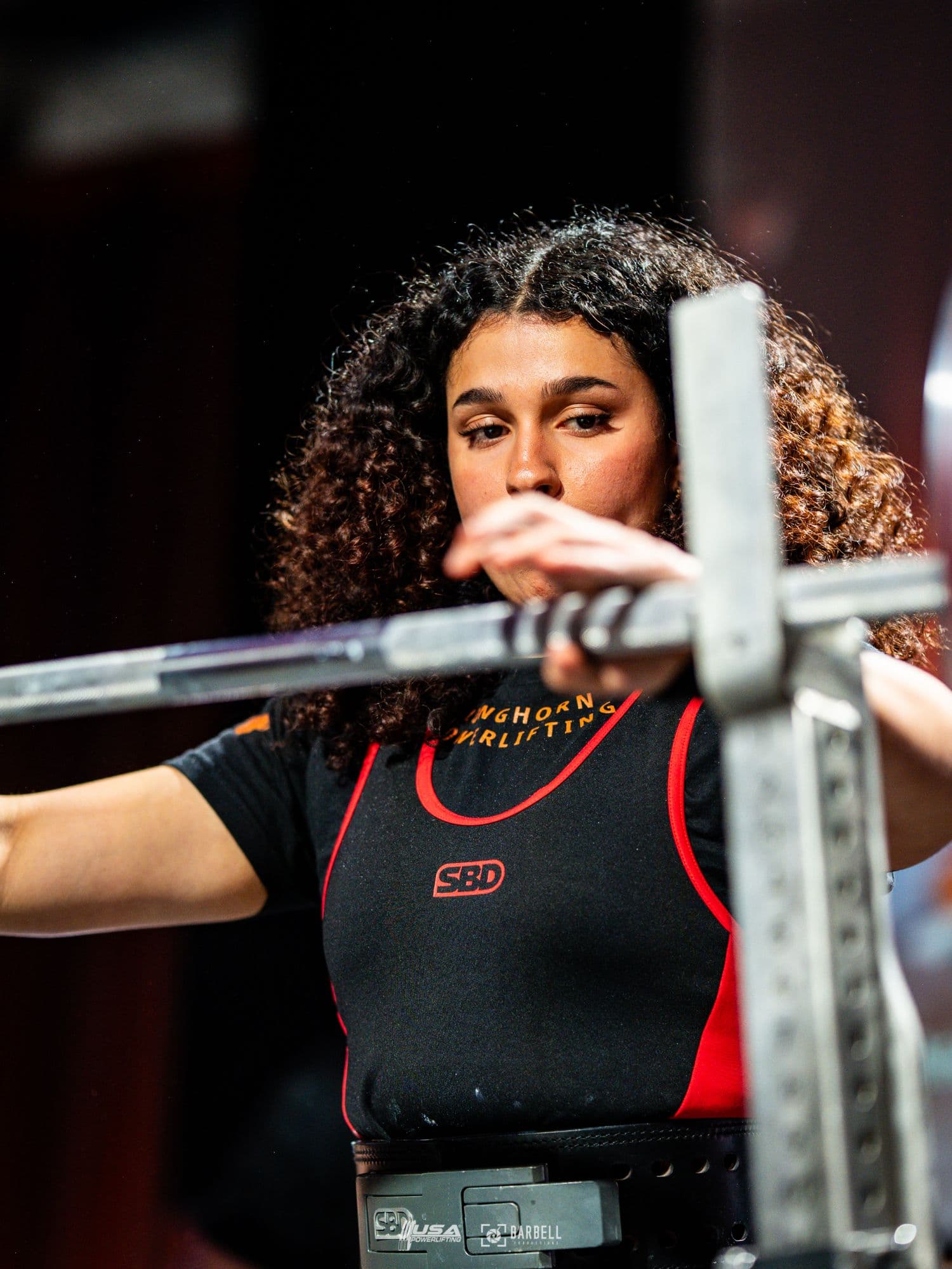 Sara Pishkar setting her grip on the barbell before a lift